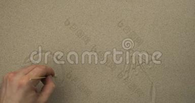 用棍子在沙子上画画。 <strong>大海背景</strong>上的雨伞，太阳和鸟。