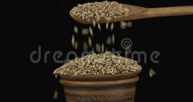 黑麦粒从一个木勺上得到<strong>足够</strong>的睡眠在一堆种子在一个粘土碗。