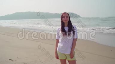年轻女子在海滨赞许地点头. 成年黑发女子站在沙滩上表示同意