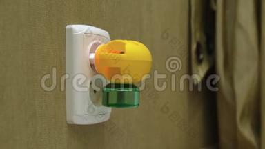 在卧室的墙上，将电动液体<strong>驱蚊</strong>器插入电动插座。