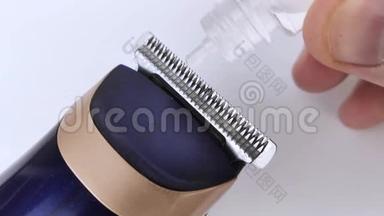 剪发器叶片润滑的宏观视频。 特写镜头显示水滴是如何落在打字机上的。