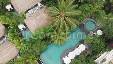 有人要上去。 豪华酒店泳池中的蔚蓝水景，热带丛林和棕榈的草顶别墅