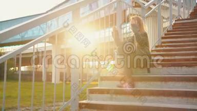 穿着黑色皮夹克的少女坐在楼梯上晒太阳。 穿皮夹克的摇滚女孩摆姿势