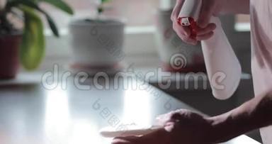 那人`手按下防腐喷雾剂，把它洒在纸巾上，按下红色的按钮，慢慢地靠近