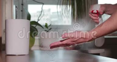 男人正在用消毒器清洗双手，在喷瓶、卷纸巾、消毒手部皮肤期间