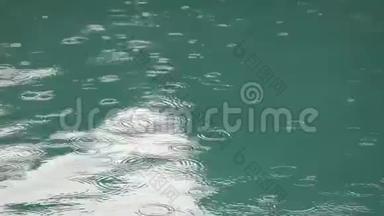 热带夏季雨溅入游泳池.. 在暴风雨和雨滴落进游泳池的时候关闭游泳池