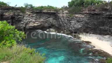 美丽的景色从悬崖到海浪撞击在绿色植物背景上的海岩石。 断滩