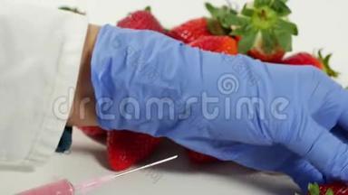 戴手套的女人用注射器。 水果和蔬菜的基因改造