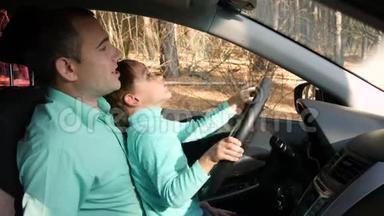 一个快乐的父亲坐在车里和他的儿子玩。 那个男孩假装开汽车转动方向盘。 家庭