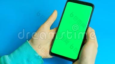 使用绿色屏幕的智能手机。 手滚动页面，<strong>点击触摸屏</strong>。 上面的风景。 铬键