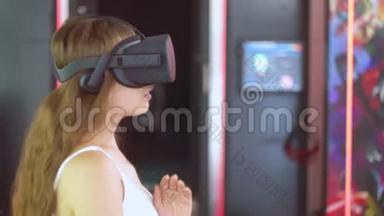 戴着虚拟现实眼镜的年轻女孩用手做动作，就好像在敲近物