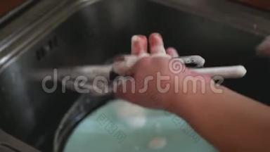 女人在厨房洗手池洗盘子-在家做家务。 洗碗，慢动作，静态相机