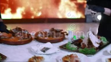 厨师在一个大屏幕上用人工生火切下新鲜煮熟的肉。 迪斯科环境。 光