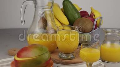 果篮和一杯果汁。新鲜<strong>芒果汁</strong>，橙汁。桌子上的水果篮。新鲜水果和果汁