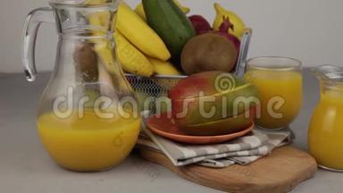 一杯果汁。黄色<strong>清爽</strong>的夏季<strong>饮料</strong>。新鲜芒果汁，橙汁。桌子上的水果篮。新鲜水果和ju