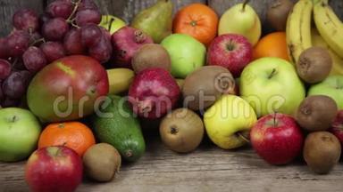 一套不同的水果放在木制的餐桌上。香蕉，<strong>芒</strong>果，<strong>苹果</strong>，鳄梨，猕猴桃，石榴，橘子，橘子，梨