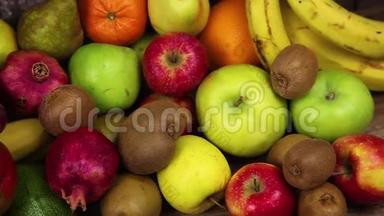 一套不同的水果放在木制的餐桌上。香蕉，<strong>芒</strong>果，<strong>苹果</strong>，鳄梨，猕猴桃，石榴，橘子，橘子，梨