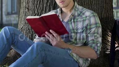 一个人在树下读着吸引人的书，全神贯注地看着情节，渴望读书