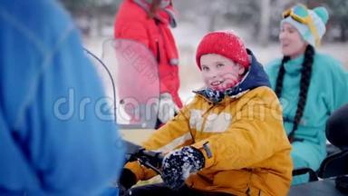 冬季森林。 一个小男孩坐在雪地车上，拧着煤气手柄。
