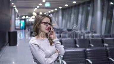 年轻漂亮的女孩在空无一人的机场候机楼打电话