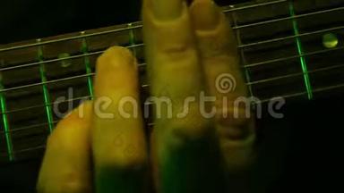 一个男人的手的特写镜头<strong>拿起</strong>电吉他的和弦。