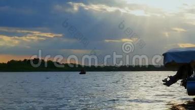 日落时在湖上渔船上的<strong>渔民剪影</strong>。