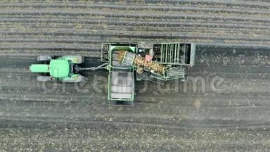 农作物，农耕，农业的理念.. 一个带土豆的传送带在绿色拖拉机上工作。