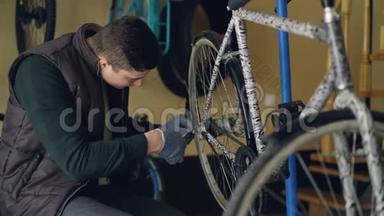 戴着手套的英俊男军人<strong>正在</strong>用专业工具<strong>修理</strong>自行车后轮。 自行车备件和