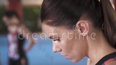 俯视图：一位<strong>运动</strong>型妇女在呼吸沉重时低着头的侧视图。她脸上<strong>出汗</strong>了。纵断面纵向视图。