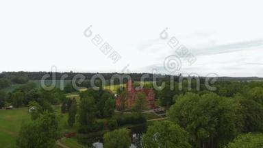 在拉脱维亚的老城堡庄园上空飞行-夏季从上面俯瞰的Jaunmoku皮尔和周围的绿树
