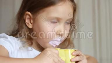 小女孩吃乳制品酸奶。 小孩用勺子吃奶酪。 肖像特写